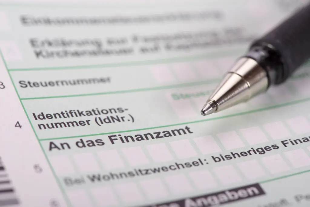 Nahaufnahme eines deutschen Steuerformulars mit einem Stift, der auf das Feld "An das Finanzamt" zeigt.