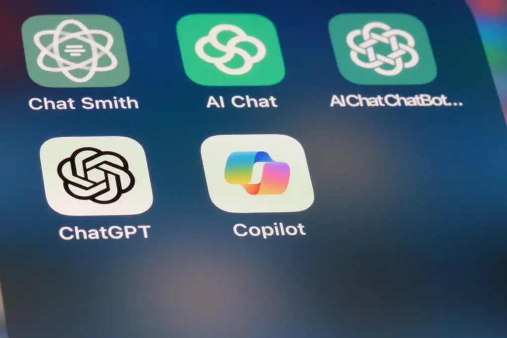 Smartphone-Bildschirm mit Icons von KI-Apps wie ChatGPT, Copilot, Chat Smith und AI Chat.