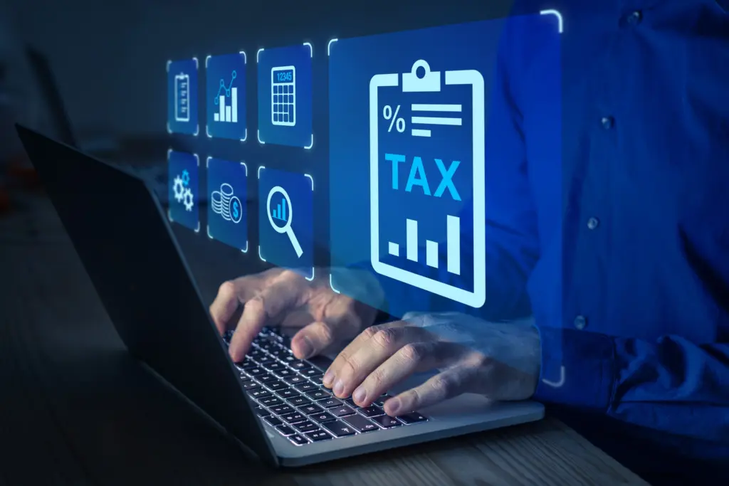 Person tippt am Laptop, umgeben von digitalen Symbolen zu Steuern, Finanzen und Datenanalyse.